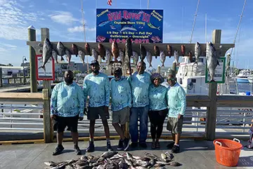 Group holding grouper caught offshore during a Full Day trip from Carolina Beach